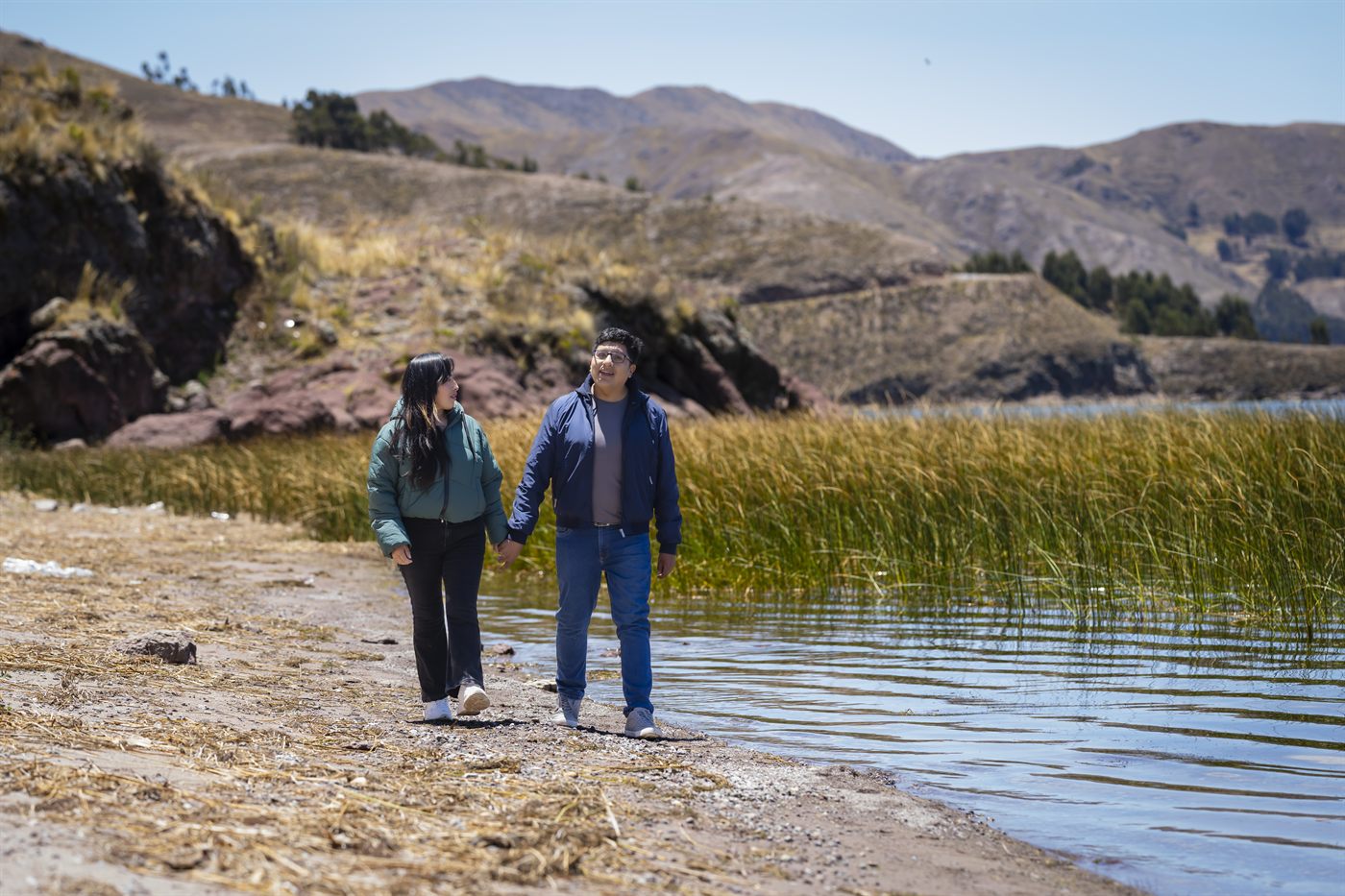 Los novios pasean junto al lago entre los cerros